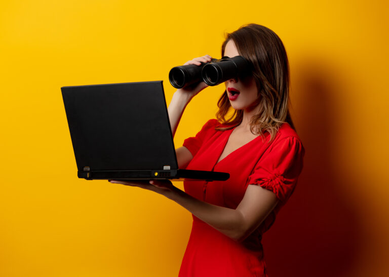 woman in red dress with binocular and laptop computer